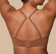 India demonstrates the racerback conversion of the Base T-Shirt Bra in Brown, showing the versatility of the adjustable straps.