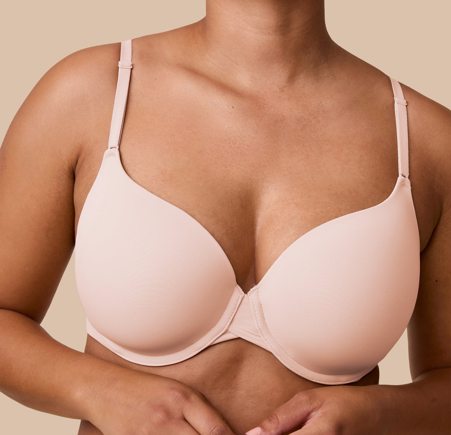 A close-up image of India wearing the Base T-Shirt Bra in Rose, focusing on the ultra soft fabric and lightly contoured cups.