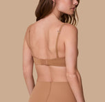 Gracie displays the back of the Base T-Shirt Bra in Tan, highlighting the adjustable hook-and-eye closure and the slim, adjustable straps.