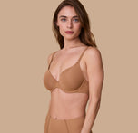 Gracie poses in a three-quarter angle wearing the Base T-Shirt Bra in Tan, showing the bra's contoured fit and comfortable structure.