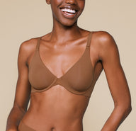 Mariah wearing the Bliss Unlined Bra in Brown. The natural contour of the cups and comfortable front adjusting straps are highlighted. sizing: Mariah wears size 32D