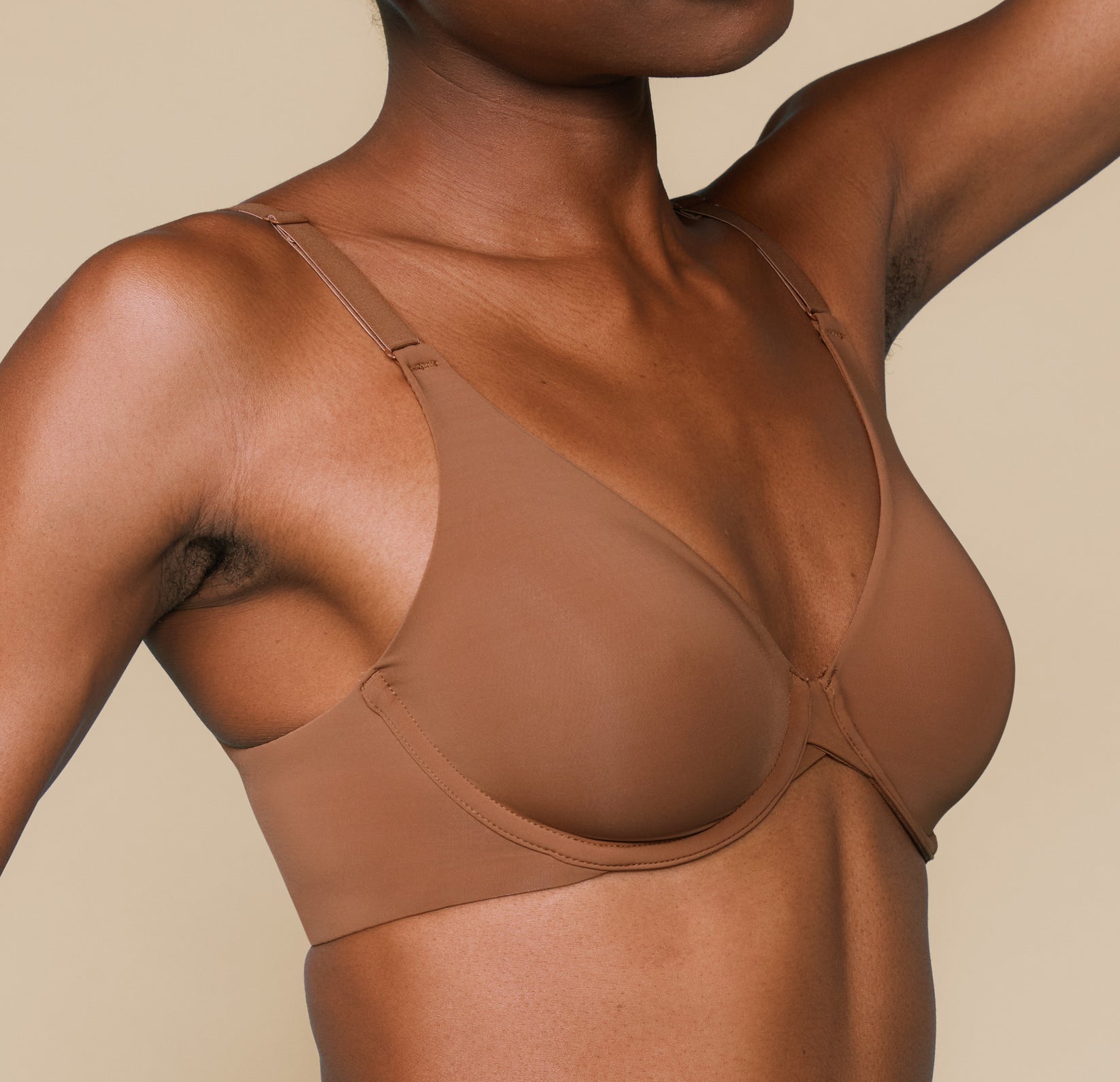 Close up view of Mariah wearing the Bliss Unlined Bra in Brown. The natural contour of the cups and comfortable front adjusting straps are highlighted.