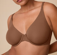 Close-up of India wearing the Base Unlined Bra in Brown, highlighting the underwire structure and natural shape created by the unlined cups.