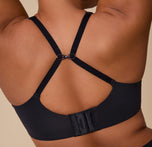 A back view of India wearing the Base Unlined Bra in Black with the straps adjusted to a racerback style.