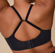 A back view of India wearing the Base Unlined Bra in Black with the straps adjusted to a racerback style.