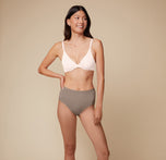 Anna poses wearing the Base Unlined Bra in Quartz with the Bliss Highwaist in Desert.