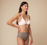 Three quarter view of Anna wearing the Base Unlined Bra in Quartz. The thick, comfortable band and plunging neckline are emphasized. 