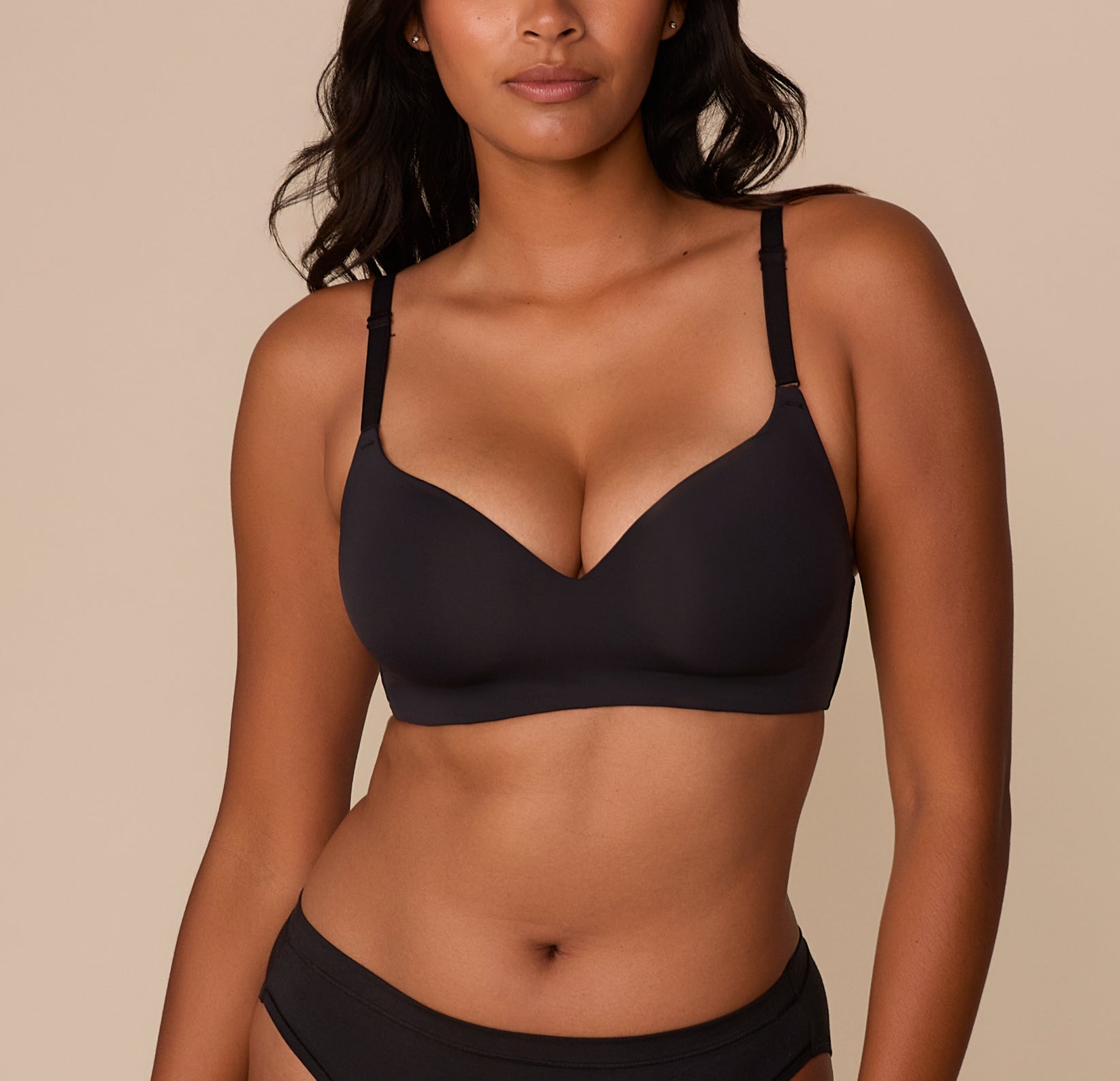Front view of Victoria wearing the Base Wirefree T-Shirt Bra in Black. The lightly lined cups and smooth microfiber fabric offer a sleek, comfortable fit with a plunging neckline and adjustable straps. sizing: Victoria wears size 32DD