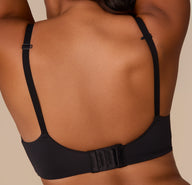 Close-up of the back of Victoria wearing the Base Wirefree T-Shirt Bra in Black. The image emphasizes the smooth back band and three-row hook-and-eye closure.