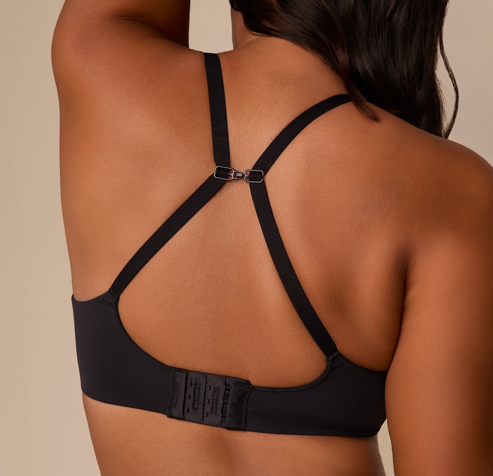 Victoria wearing the Base Wirefree T-Shirt Bra in Black with straps clipped into a racerback using the sliding J-hook. The image shows the versatile fit option and supportive back band.