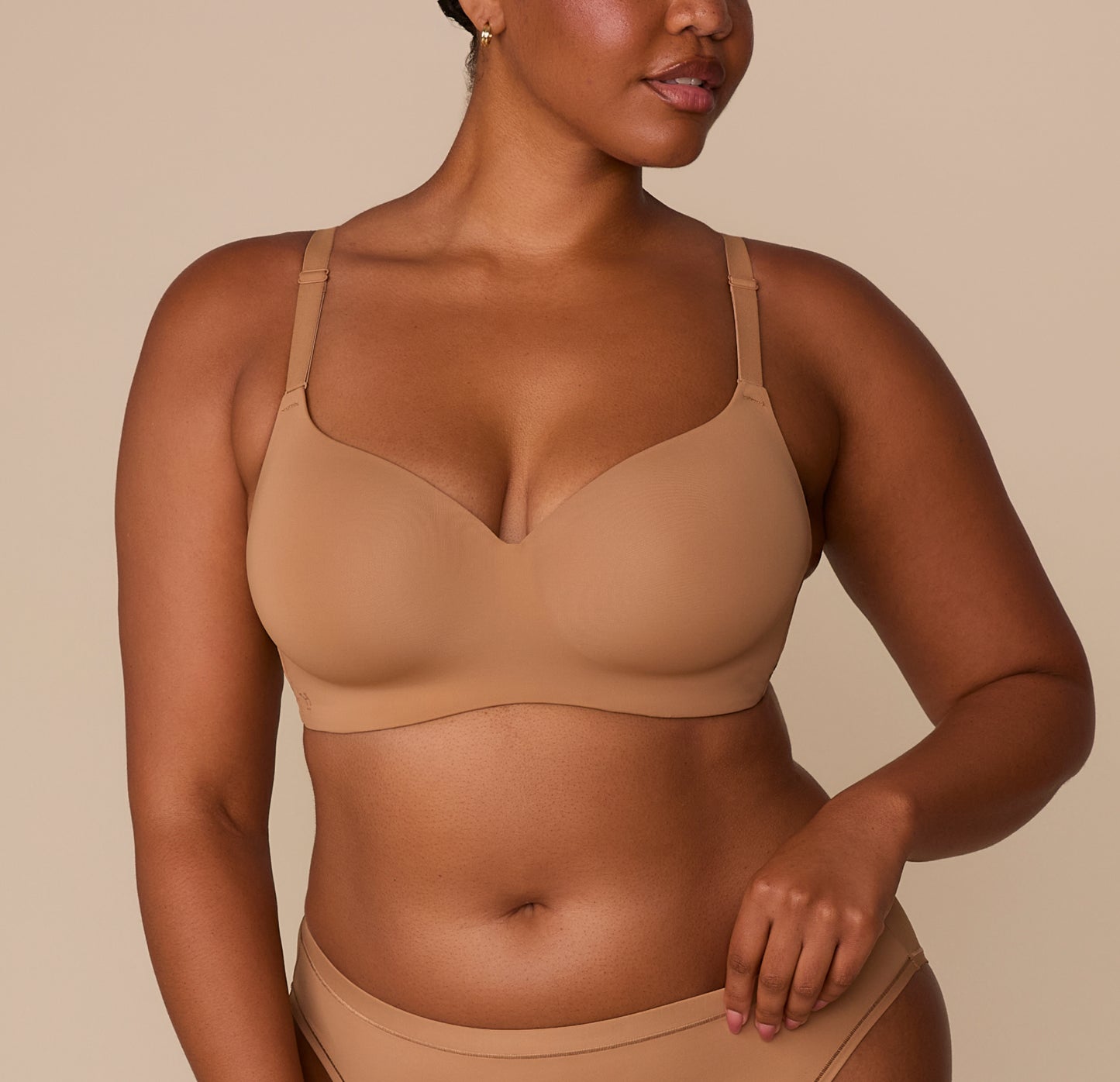 Front view of Zarria wearing the Base Wirefree T-Shirt Bra in Tan. The image highlights the bra’s lightly lined cups, V-neckline, and soft microfiber fabric. sizing: Zarria wears size 38D