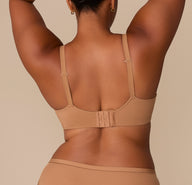 Back view of Zarria wearing the Base Wirefree T-Shirt Bra in Tan. The hook-and-eye closure and fully adjustable straps are shown, designed for everyday comfort and fit flexibility.