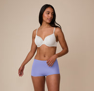 Full-body shot of Nemesis in motion, showcasing the comfortable, everyday fit of the Base T-Shirt Bra in Frost and Bliss Boyshort in Dusk.