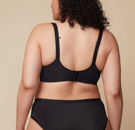 A close-up of Bianca’s back in the Base Wirefree Bra in Black. The ballet back design offers sleek support, while the J-hook feature is highlighted, allowing easy conversion to a racerback.