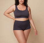 Bianca stands with her hands resting by her sides, wearing the Lounge Boyshort in Charcoal. The image highlights the comfortable fit and soft fabric of the boyshort. sizing: Bianca wears size 2XL