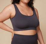 Close-up shot of Bianca wearing the Lounge Rib Scoop Bralette in Charcoal, emphasizing the soft ribbed texture and scoop neckline.