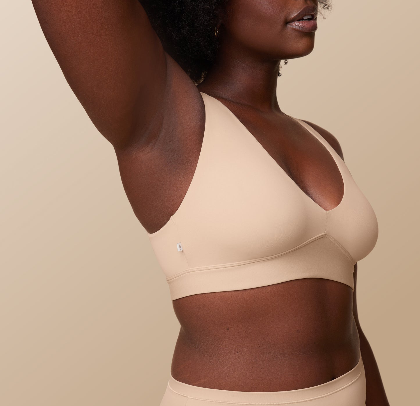 Side view of Akesha in the Bliss Plunge Adjustable Bralette and Bliss Highwaist Brief in Beige, highlighting the adjustable straps and smooth fabric of the bralette, perfect for all-day wear. 