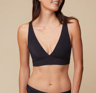 Anna in the Bliss Plunge Adjustable Bralette and Bliss Bikini, looking to her left with a relaxed pose. sizing: Anna wears size Small. Sizes L-4XL have higher center in front for additional support.