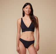 Anna wearing the Bliss Plunge Adjustable Bralette and Bliss Bikini in Black, standing confidently facing forward.