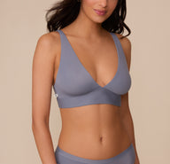 Front view of model Marcela wearing the Bliss Plunge Adjustable Bralette in Steel. The image highlights the deep V-neckline and wide straps designed for wireless lift and comfort. sizing: Marcela wears size Small