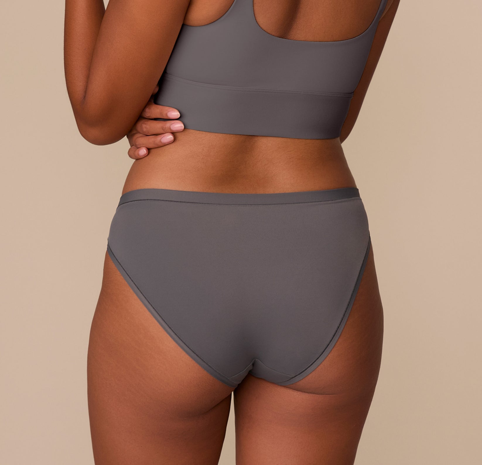 Back view of Victoria in the Bliss Bikini in Smoke, showing the fuller coverage and tagless design made with ultra-soft microfiber fabric.
