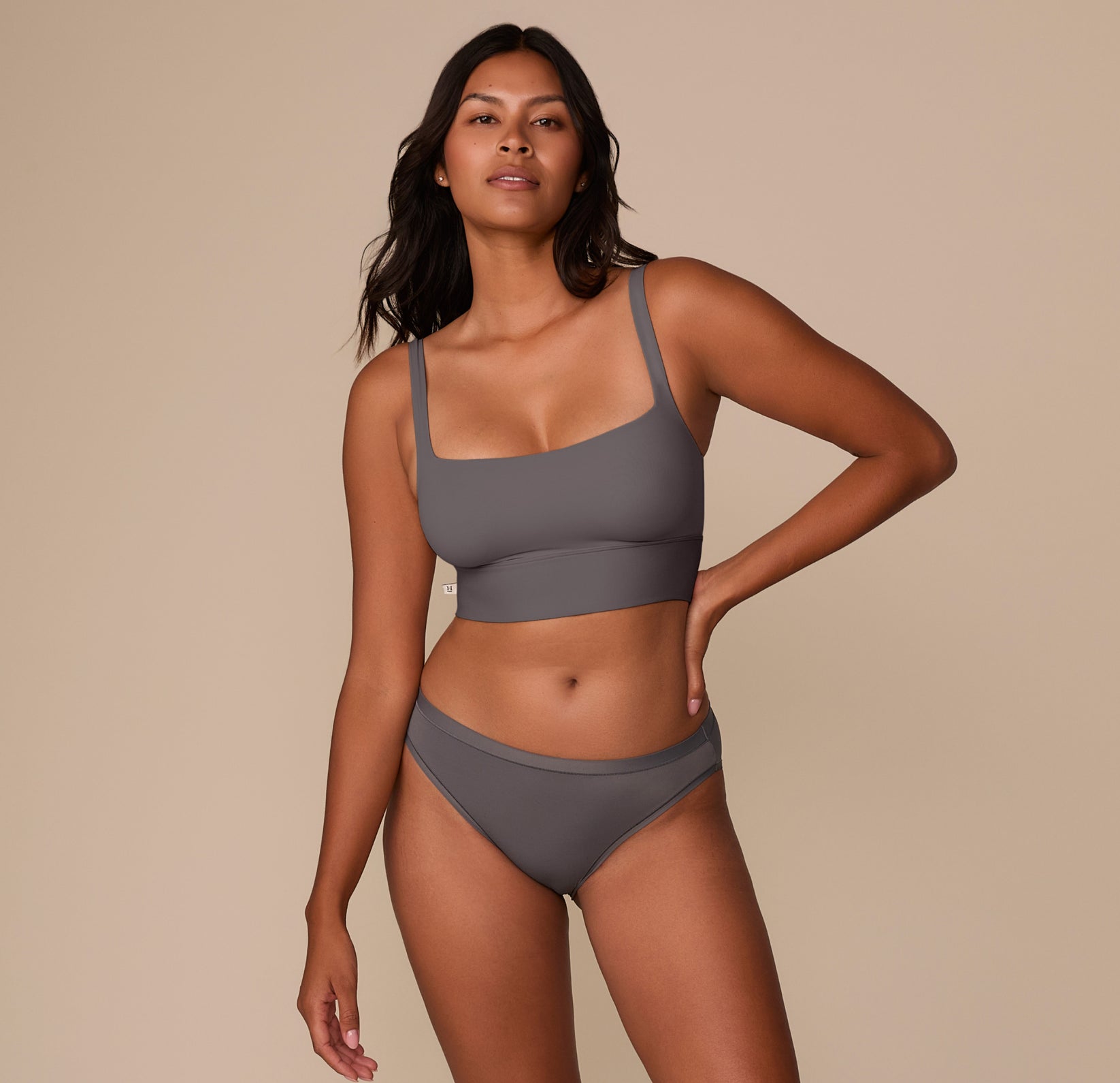 Full body, front-facing image of Victoria wearing the Bliss Bikini and matching Bliss Square Neck Bralette in Smoke, highlighting the coordinated set and comfortable, everyday style.