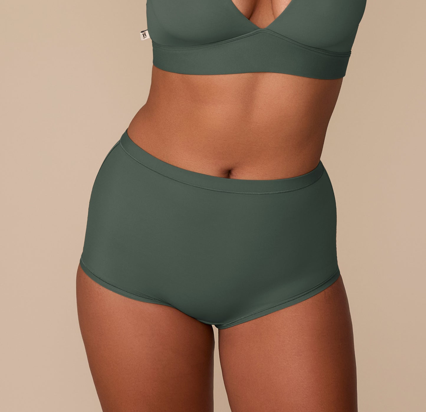 Victoria wearing the Bliss Boyshort in Fir, front view, showing the high-rise fit and smooth waistband. sizing: Victoria wears size Medium