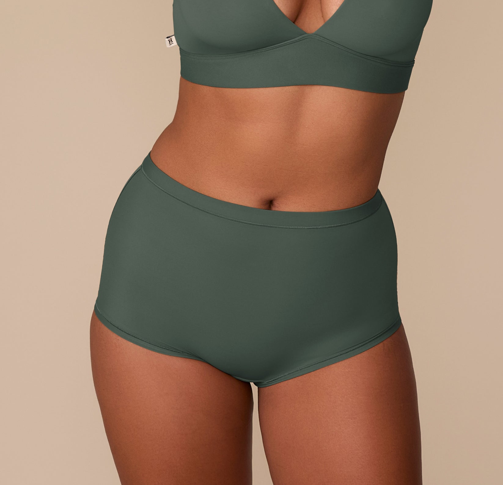 Victoria wearing the Bliss Boyshort in Fir, front view, showing the high-rise fit and smooth waistband. sizing: Victoria wears size Medium