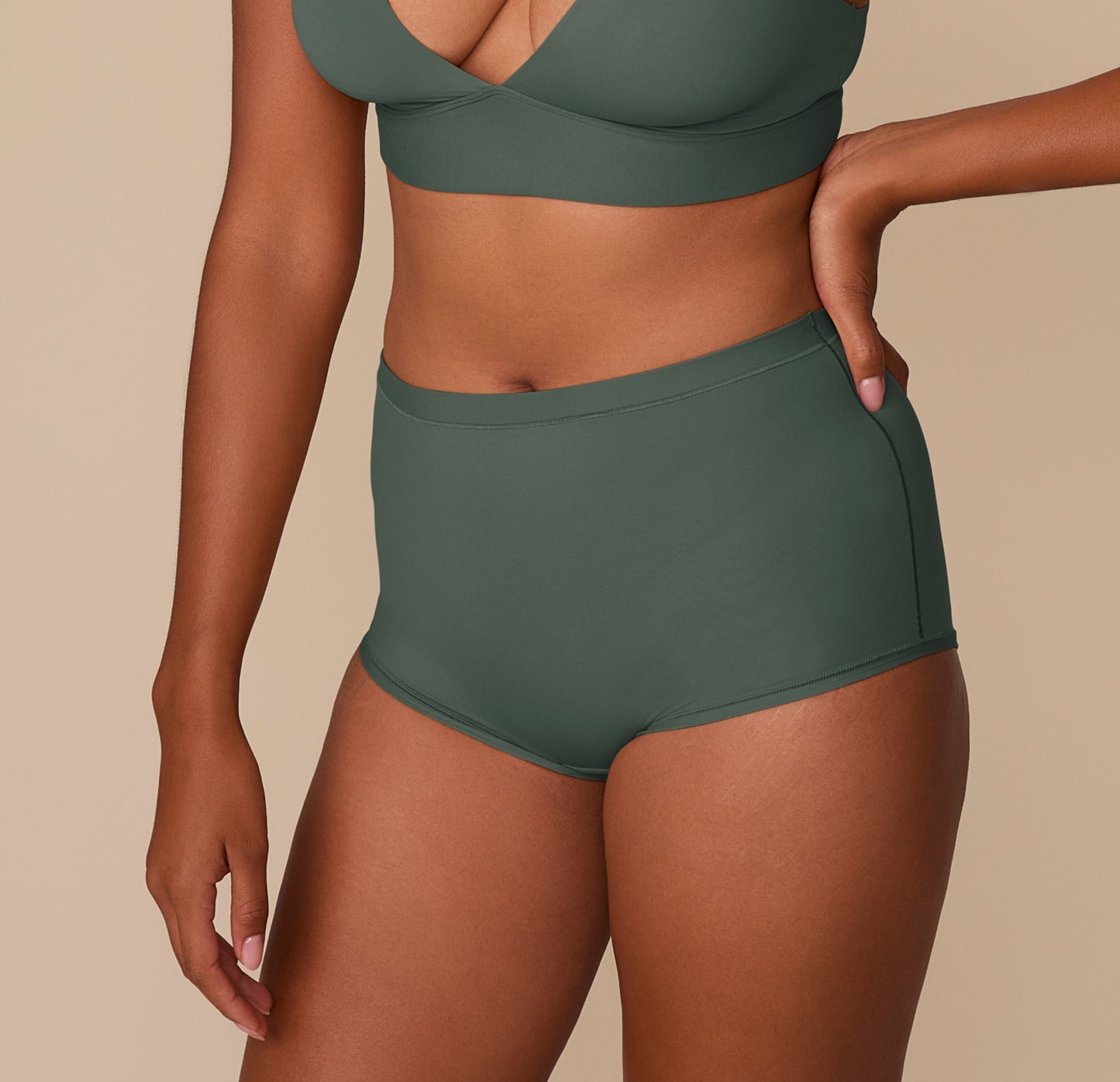 Side view of Victoria modeling the Bliss Boyshort in Fir, paired with the matching Bliss Plunge Adjustable Bralette.