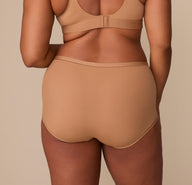 Back view of Zarria in the Bliss Boyshort in Tan, showing the wide waistband and soft, stretchy fabric that hugs the body without digging in.