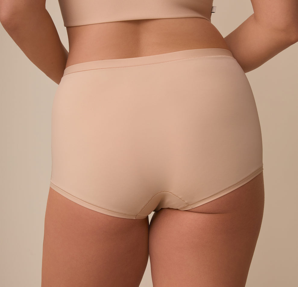 A detailed view of the back of the Bliss Boyshort in Beige on Sonnie, emphasizing the full-coverage fit and ultra-soft, microfiber fabric.