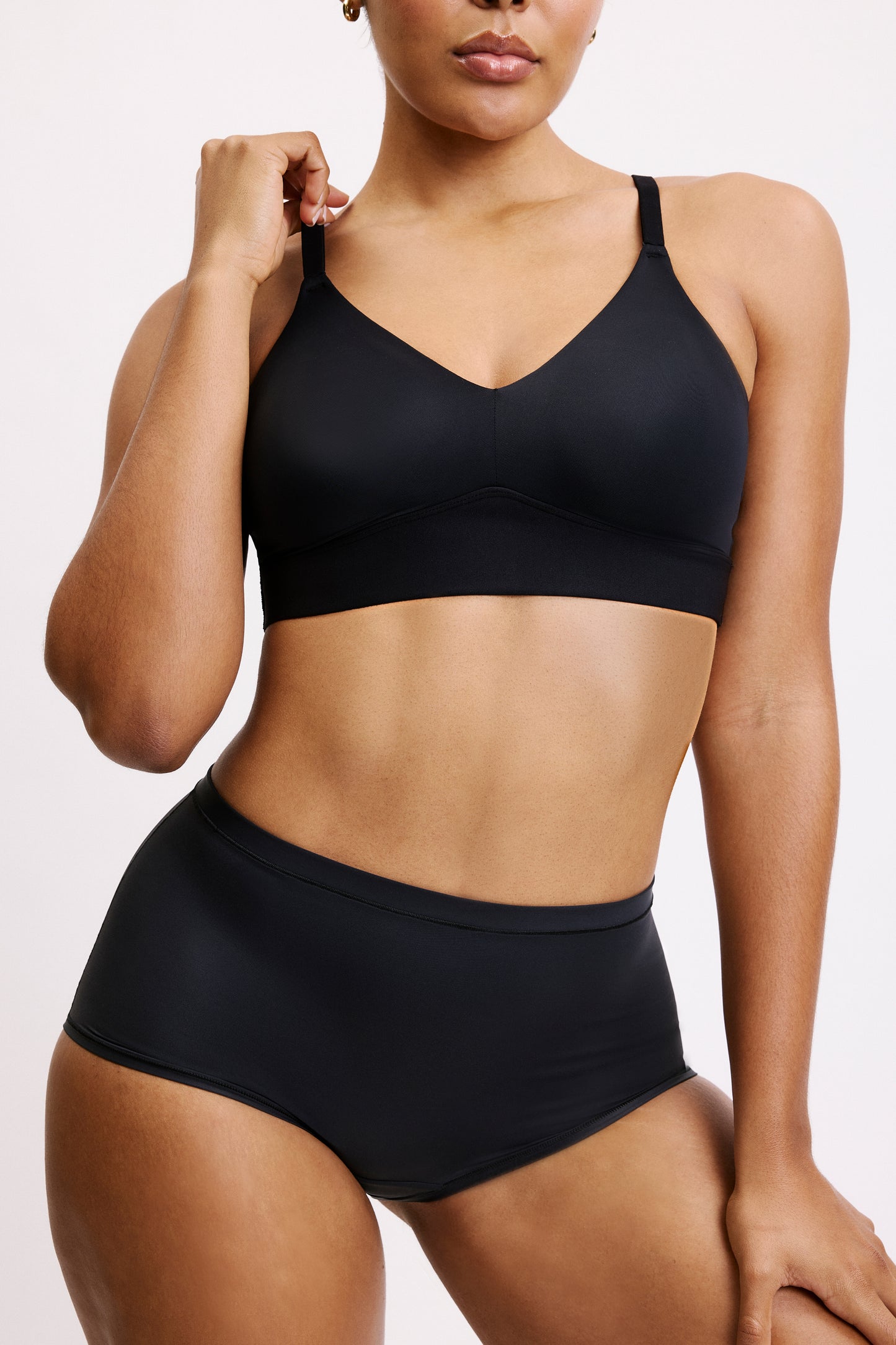 In a white studio setting, Amber wears the Bliss Boyshort in Black with the matching Bliss bralette, shown from the front to highlight the soft microfiber fabric, mid-rise waistband, and clean, no-show edges designed for everyday comfort.