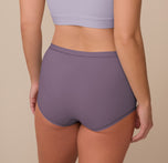Back view of Sonnie in the Bliss Boyshort in Eclipse and the Bliss Bralette in Violet. The boyshort offers full rear coverage and a smooth fit, while the bralette features a wide scoop-back design.
