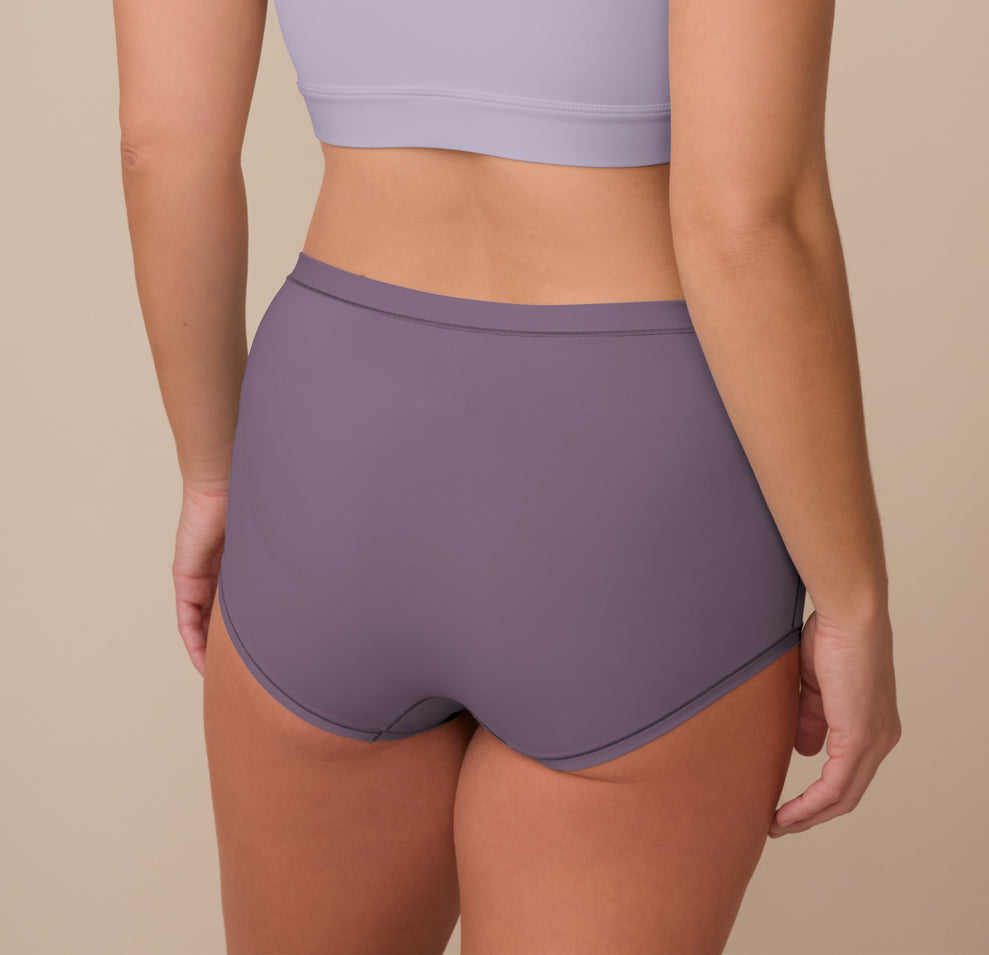 Back view of Sonnie in the Bliss Boyshort in Eclipse and the Bliss Bralette in Violet. The boyshort offers full rear coverage and a smooth fit, while the bralette features a wide scoop-back design.