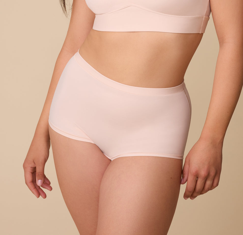 A close-up of model Emersyn wearing the Bliss Boyshort in Rose. The high-rise fit and smooth fabric provide a sleek look with full coverage. sizing: Emersyn wears size Large