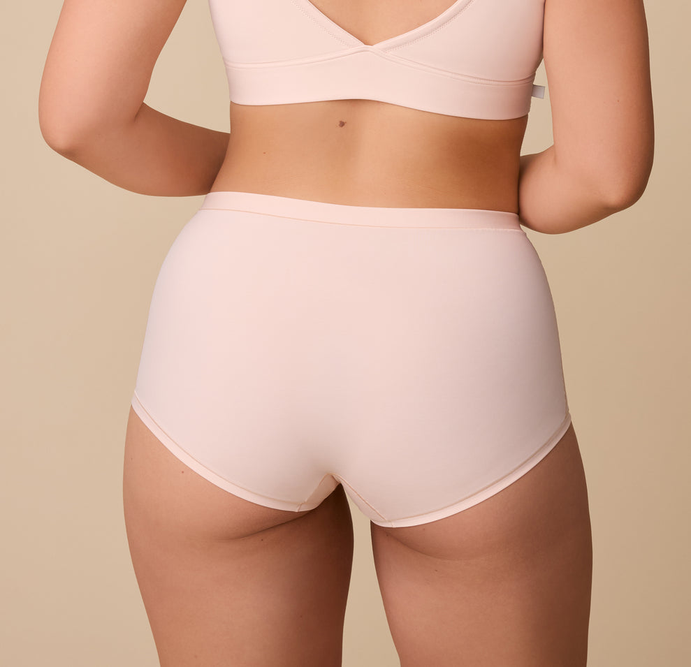 A rear view of Emersyn showcasing the full-coverage back of the Bliss Boyshort in Rose. The fabric lays flat, ensuring a no-show fit under clothing.