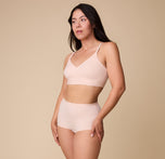 Emersyn wears the Bliss Boyshort in Rose paired with the matching Bliss Triangle Bralette, posing confidently against a neutral backdrop.