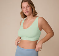 Three-quarter angle of Sonnie adjusting the waistband of the Bliss Boyshort in Glacier while wearing the Bliss Bralette in Dew, showcasing the everyday comfort and flexible fit.