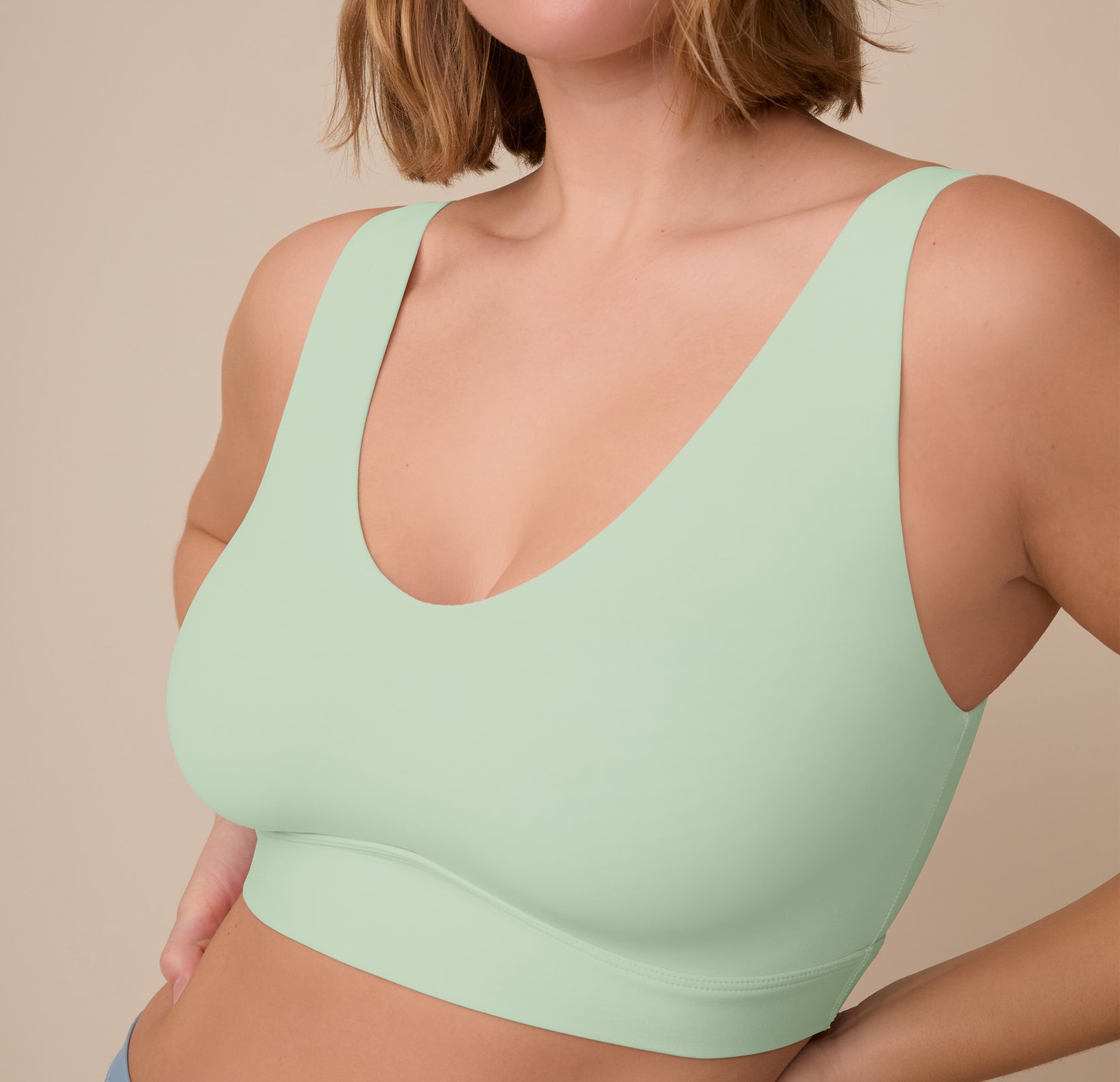 Close-up angled shot of Sonnie wearing the Bliss Bralette in Dew, focusing on the fabric’s soft stretch and smooth lines around the bust.