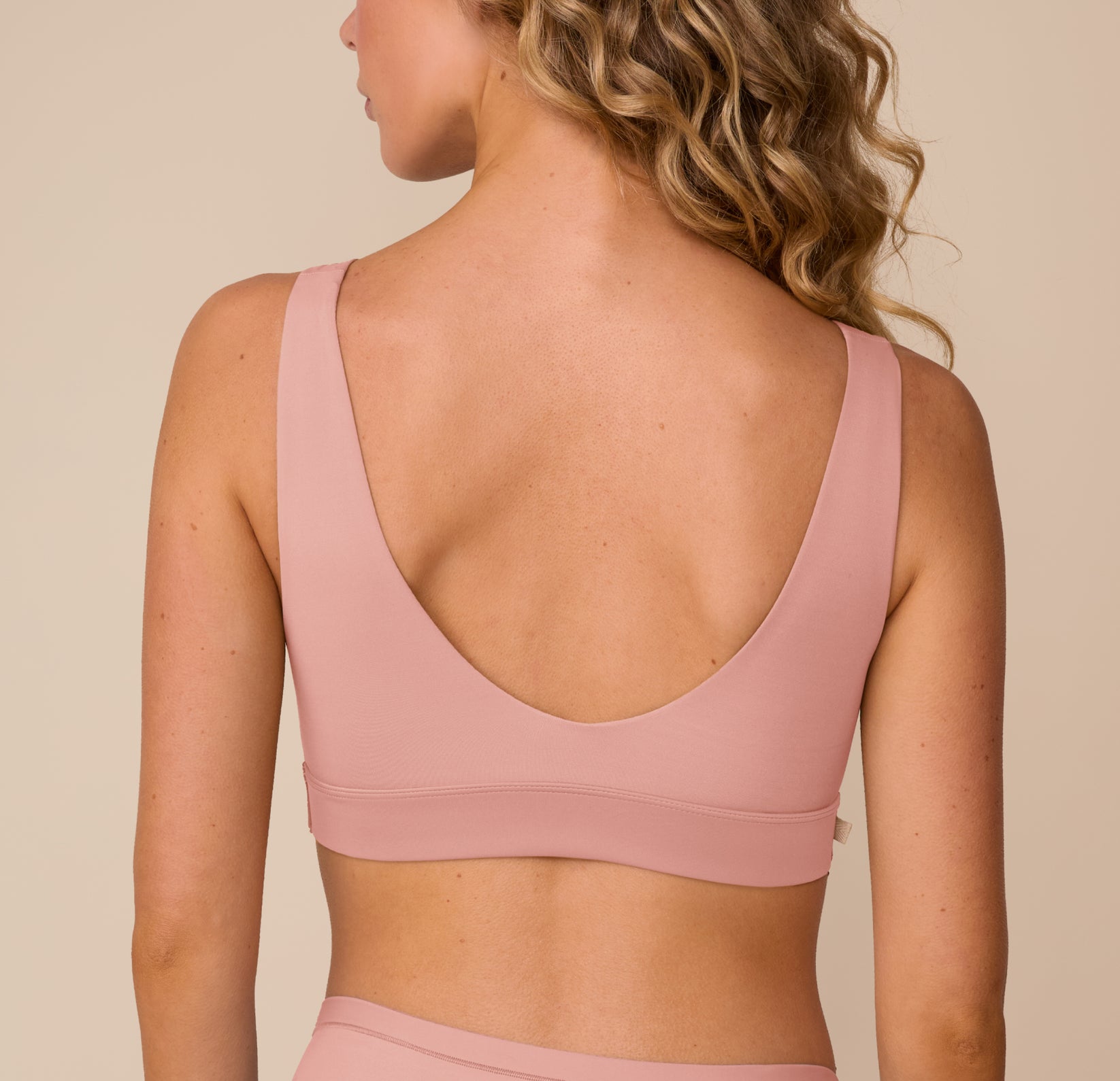 Back view of Freya in the Bliss Bralette in Dusty Rose, highlighting the low scoop back and wide supportive band.