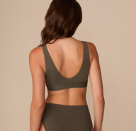 Back view of Alexis wearing the Bliss Bralette in Olive, highlighting the wide straps and full-coverage back for a smoothing effect.