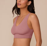 Three-quarter side view of Marcela in the Bliss Bralette in Plum, capturing the bralette’s sleek silhouette and wireless lift from the side.