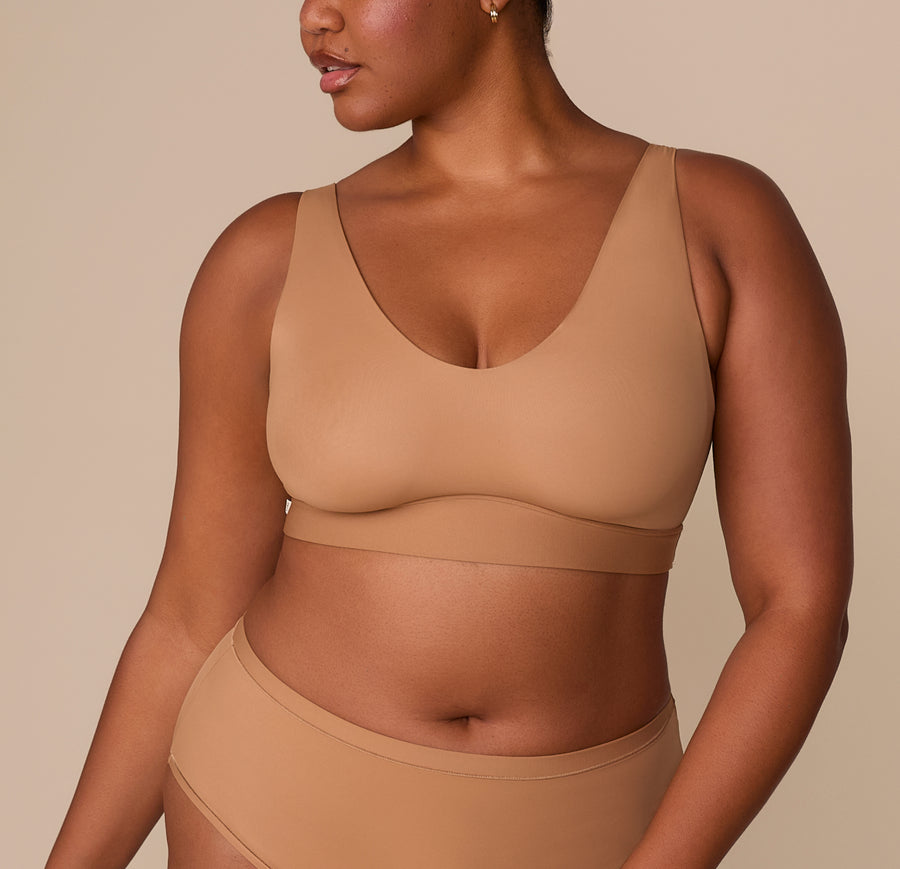 Zarria models the Bliss Bralette in Tan, highlighting its scoop neckline, wide straps, and soft molded cups. sizing: Zarria wears size XL