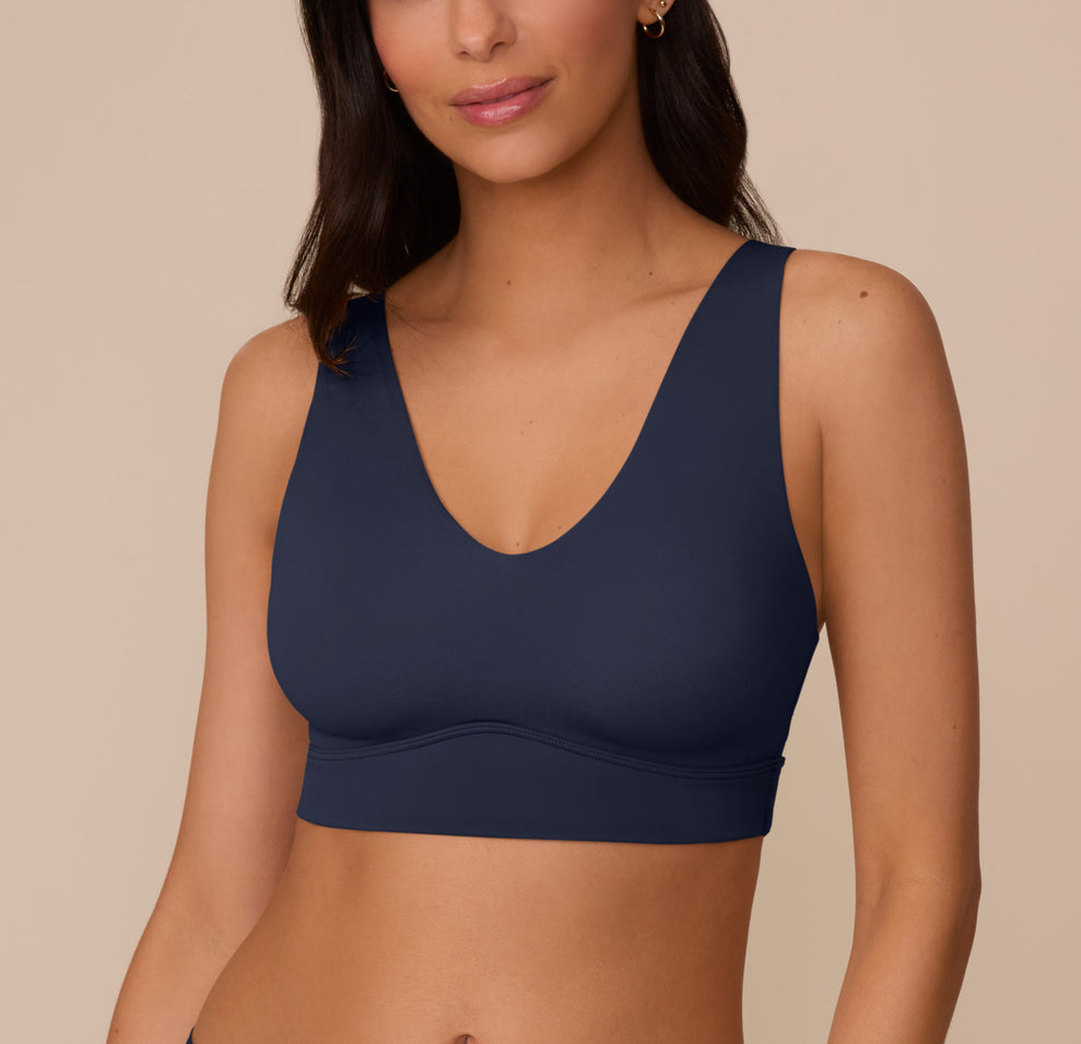 Model Marcela wears the Bliss Bralette in True Blue, shown from the front. The image highlights the plunging V-neckline, wide straps, and smooth underband for wireless support. sizing: Marcela wears size Small