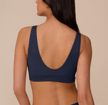 Back view of Marcela in the Bliss Bralette in True Blue. The scoop back and seamless design offer a sleek, comfortable fit under clothing.