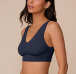 Side profile of Marcela wearing the Bliss Bralette in True Blue. The image emphasizes the soft, stretchy fabric and molded shape that provides light support without wires.