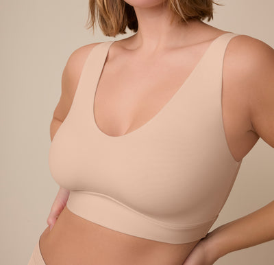 Close-up of Victoria wearing the Bliss Bralette in Beige. The lightly lined cups and minimal seams create a smooth, everyday silhouette.
