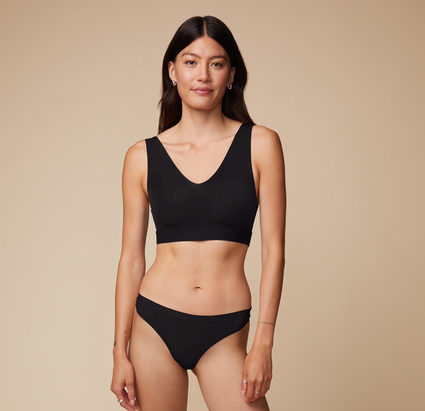 Full body view of Anna in the Bliss Bralette and matching Bliss Thong in Black. The classic color and sleek design deliver an elevated everyday look.