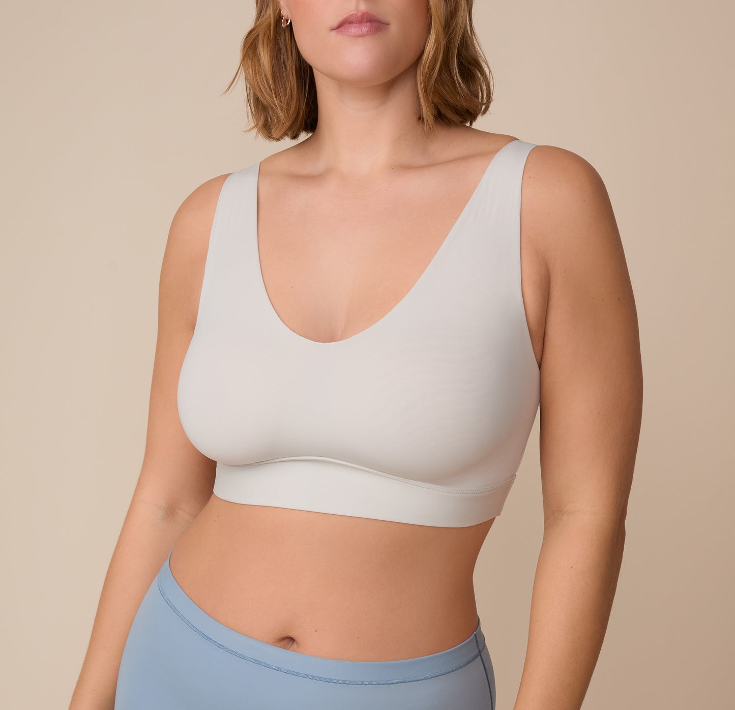 Close-up of Sonnie wearing the Bliss Bralette in Frost. The bralette features a soft scoop neckline and smooth, supportive fabric. sizing: Sonnie wears size XL