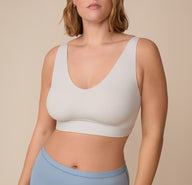 Close-up of Sonnie wearing the Bliss Bralette in Frost. The bralette features a soft scoop neckline and smooth, supportive fabric. sizing: Sonnie wears size XL